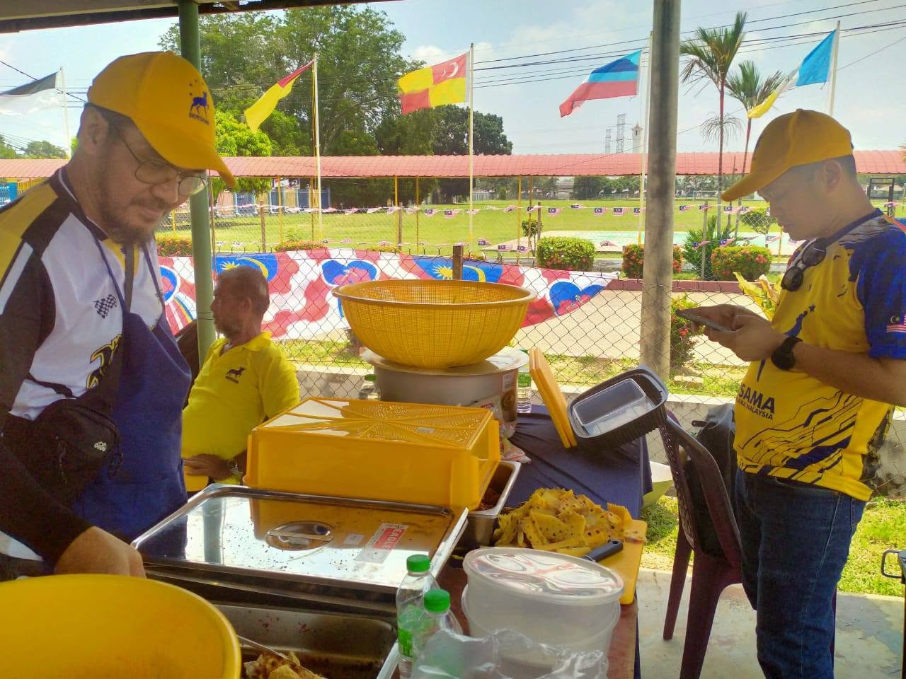 Ahli pasukan berada di meja hidangan makanan semasa kenduri.