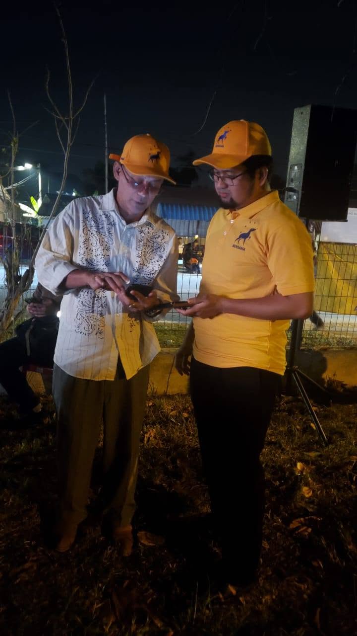 Aman Akil bersama seorang hadirin melihat telefon semasa program.
