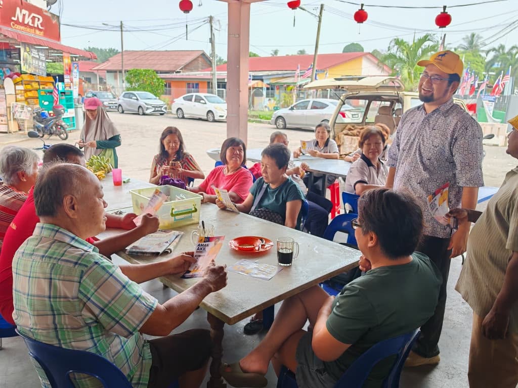 Aman Akil berbual dengan sekumpulan pengunjung di meja kedai makan.