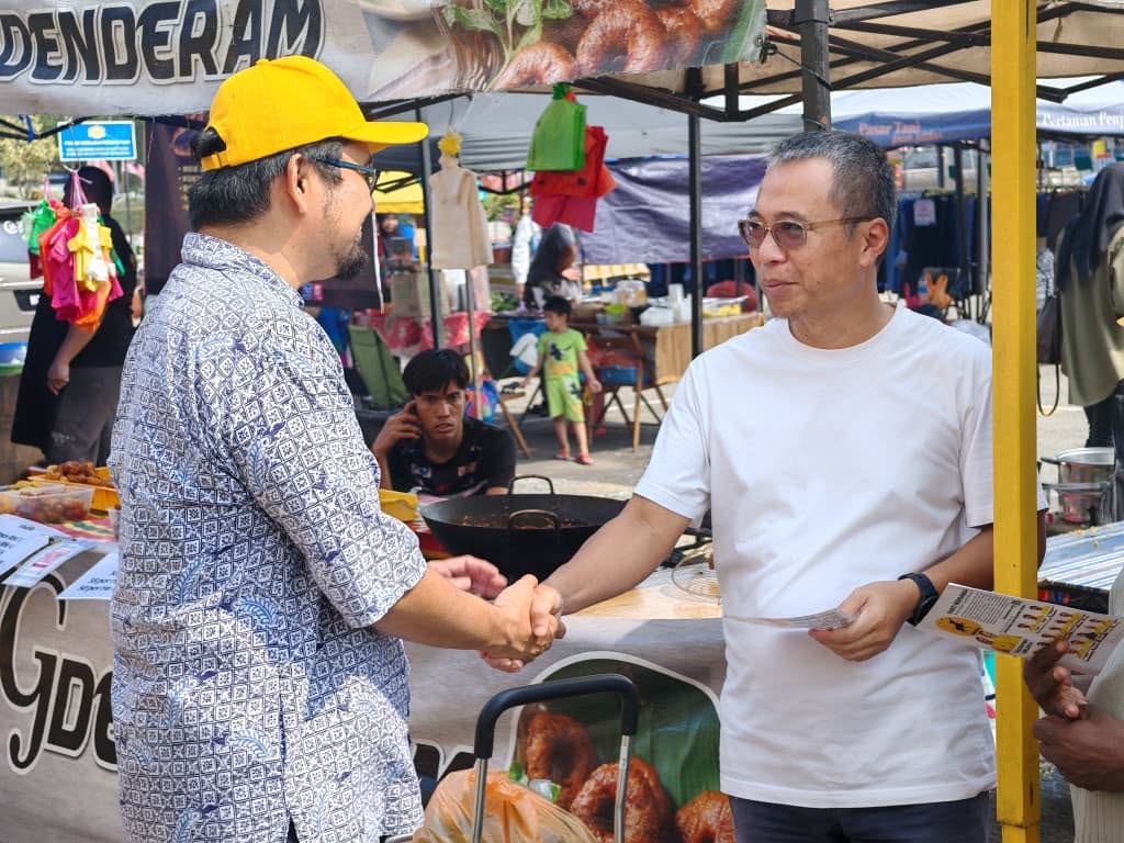 Aman Akil bersalaman dengan seorang warga setempat di kawasan gerai.