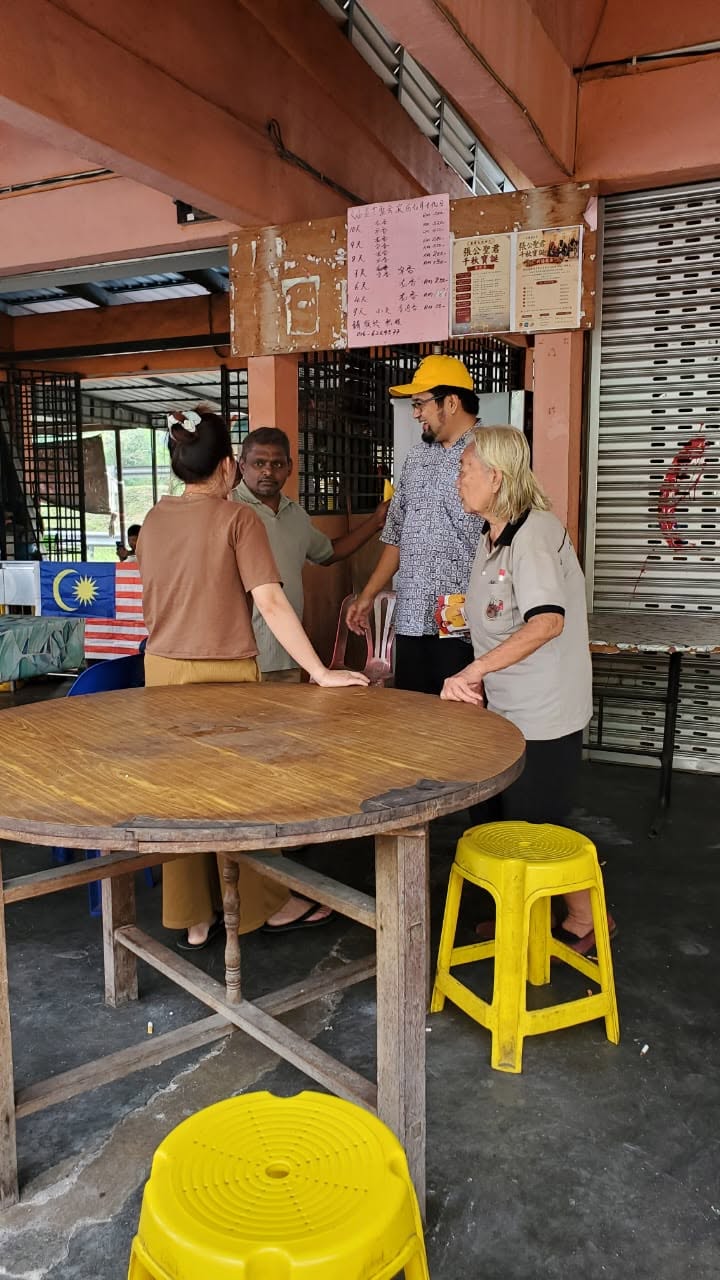 Aman Akil menyapa pengunjung berhampiran meja bulat di kedai makan.