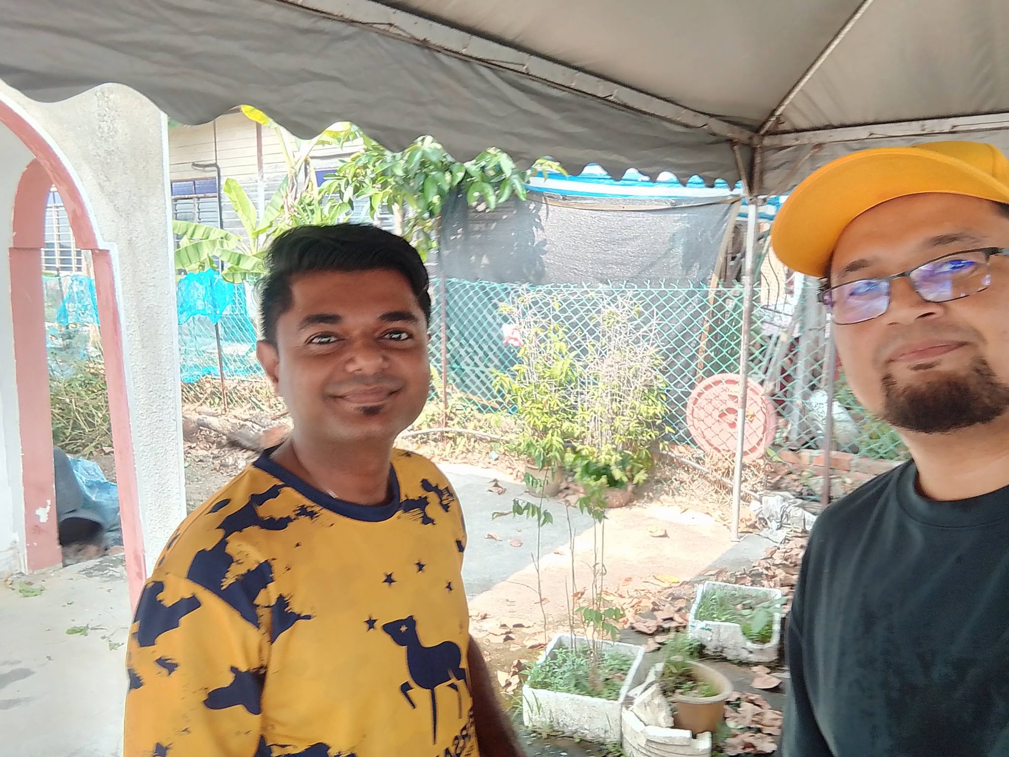 Aman Akil bergambar bersama seorang ahli pasukan di kawasan persiapan kenduri.