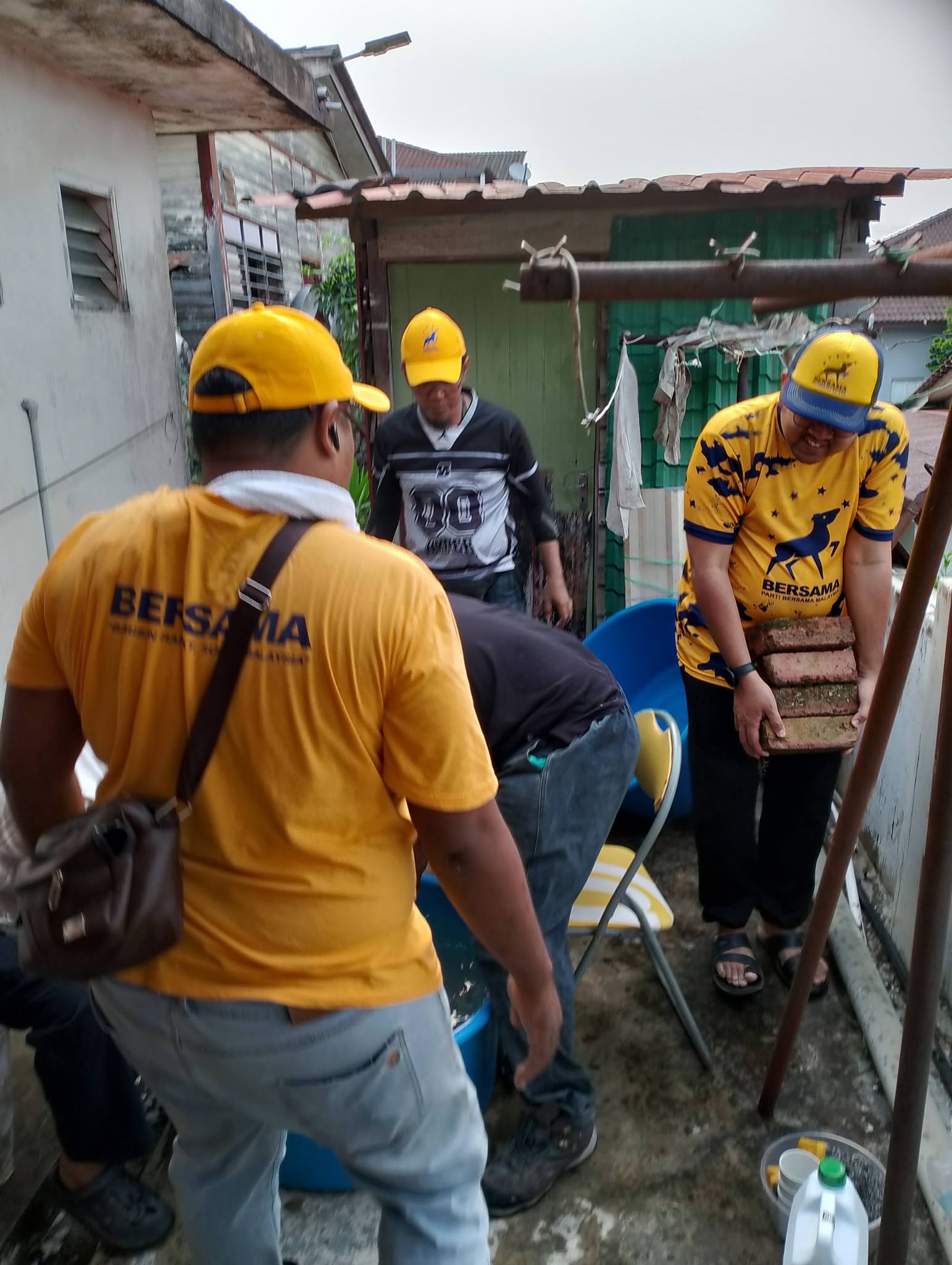 Ahli pasukan bekerjasama di ruang belakang untuk mengurus peralatan kenduri.