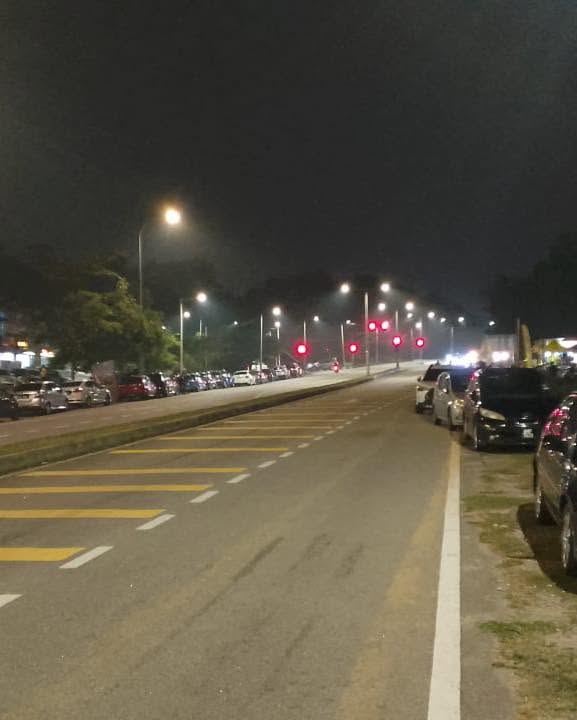 Deretan kereta di tepi jalan berhampiran lokasi program pada waktu malam.